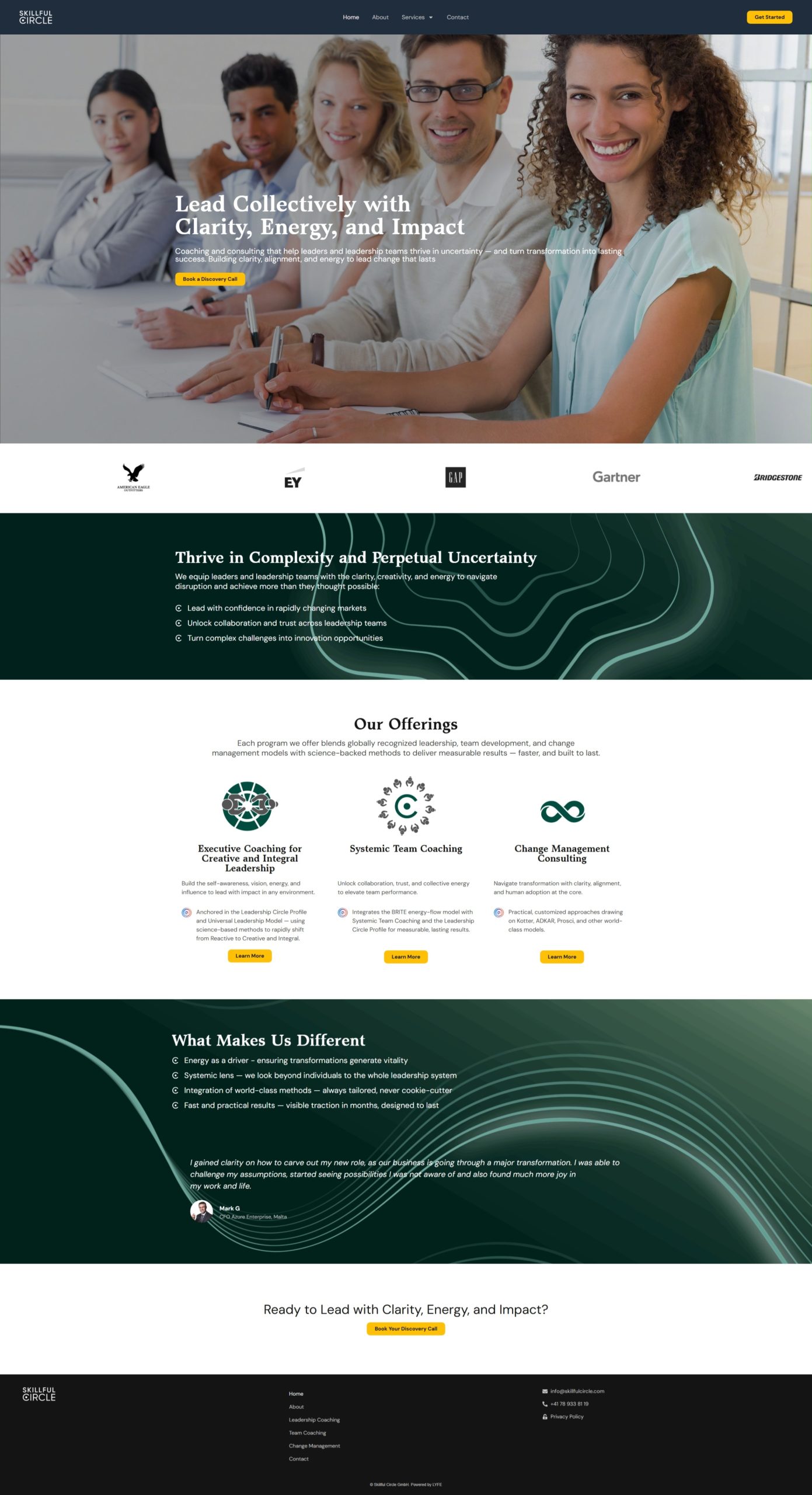 Four smiling professionals sit at a conference table, with one woman facing the camera in the foreground.